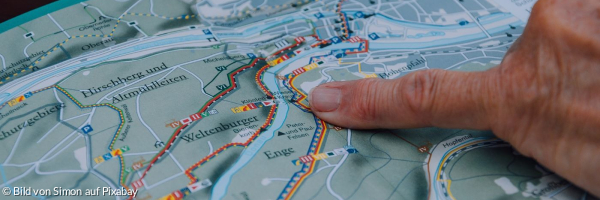 Finger auf einer Straßenkarte deutet auf einen genauen Punkt
