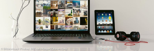 Laptop mit vielen Bildern, Tablet und Mobiltelefon mit Kopfhörer