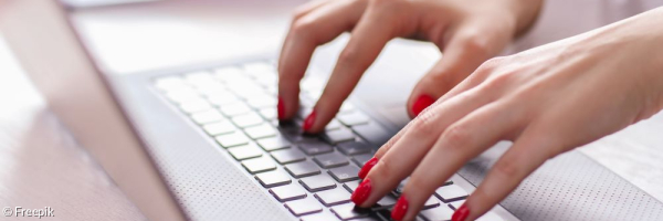 Damenhände tippen auf einer Laptoptastatur