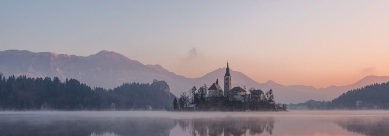 Abendstimmung am See. Im Hintergrund sieht man eine Kirche