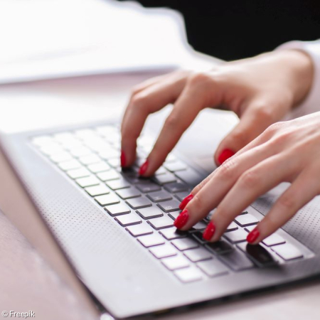 Damenhände tippen auf einer Laptoptastatur